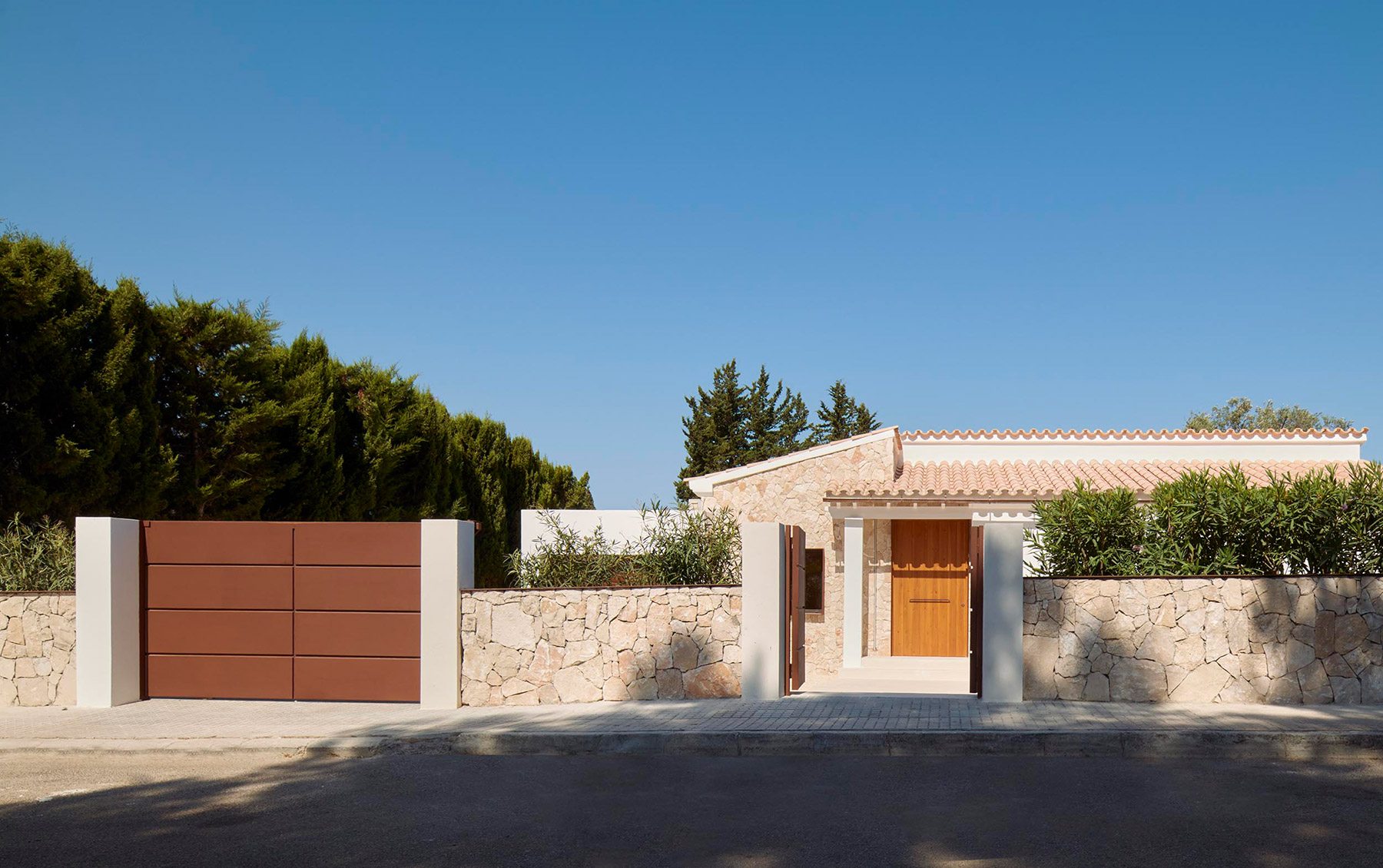 Juan David Martínez Jofre diseña una vivienda integrada en el paisaje, prolongando la cromática terrosa con la vegetación mediterránea autóctona